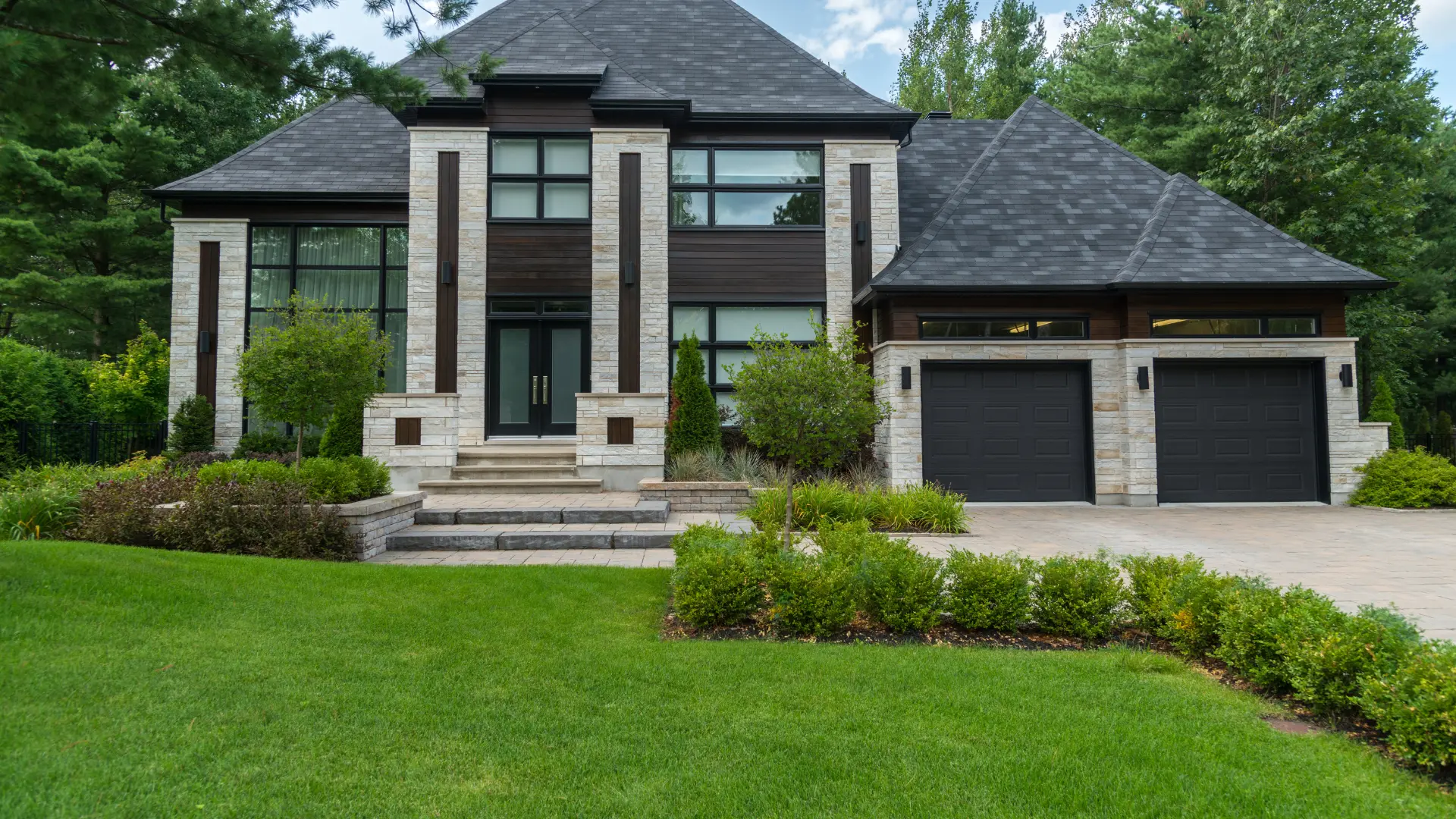 A finished paver patio and landscaped backyard by Deluxe Outdoor Services